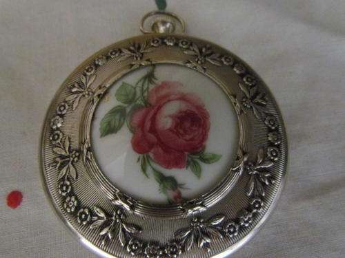 A LOVELY SILVER PLATED COMPACT WITH A ROSE IN THE MIDDLE IT LOOK LIKE A OLD WATCH!!