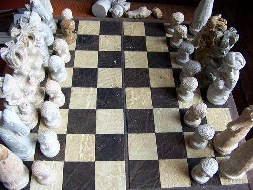 CHESS MADE OUT OF SOAP STONE ON LEATHER CHESS BOARD