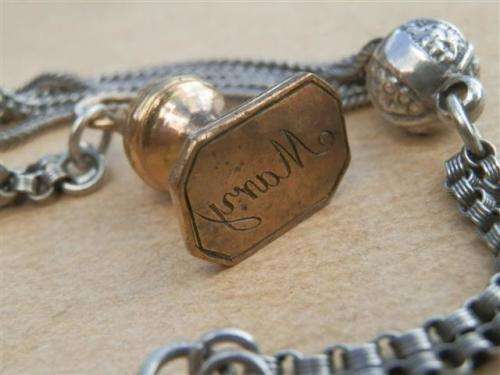 Antique lady's Albert fob chain with pocket watch and fob seal.