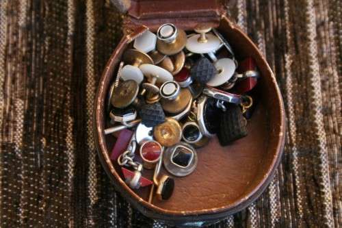 Studs Leather holder filled with several pairs of Studs and cufflinks