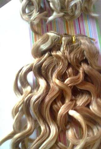 Wavy human hair extensions in blonde