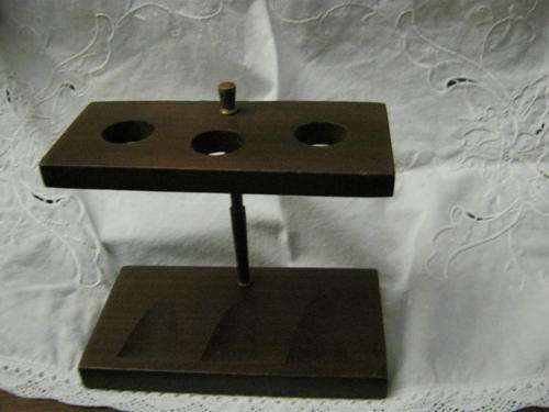 BEAUTIFUL DARK WOOD PIPE STAND  HOLDING THREE PIPES .HAVE A LOOK!!