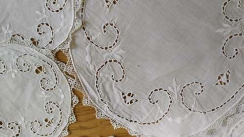 Set of twelve white embroidered doilies