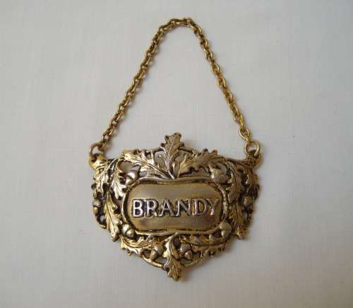 VINTAGE BRASS-PLATED BRANDY DECANTER LABEL