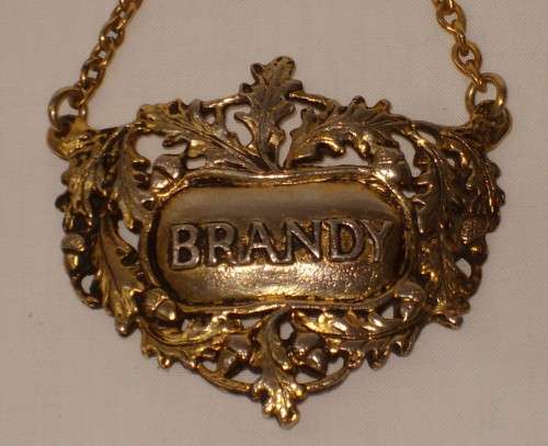 VINTAGE BRASS-PLATED BRANDY DECANTER LABEL