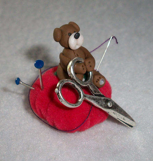 miniature teddy on a pin cushion