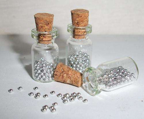 Miniature glass jar filled with silver balls.