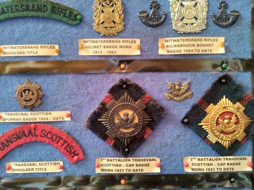 Display of South African Traditional Regiments cap/beret badges, shoulder titles and collar badges.