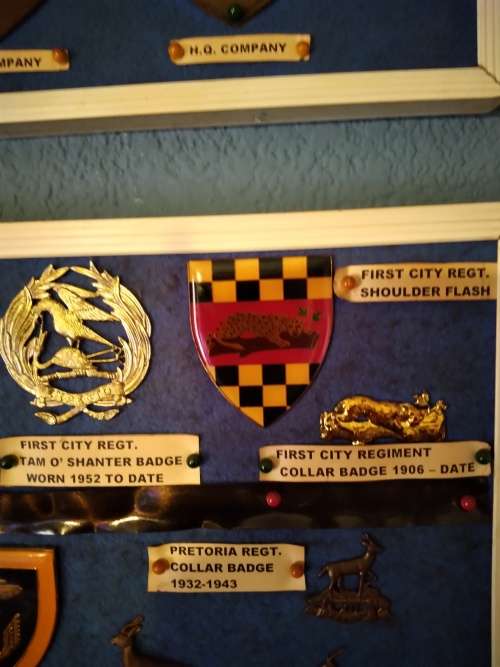 Display of South African Traditional Regiments cap/beret badges, shoulder titles and collar badges.