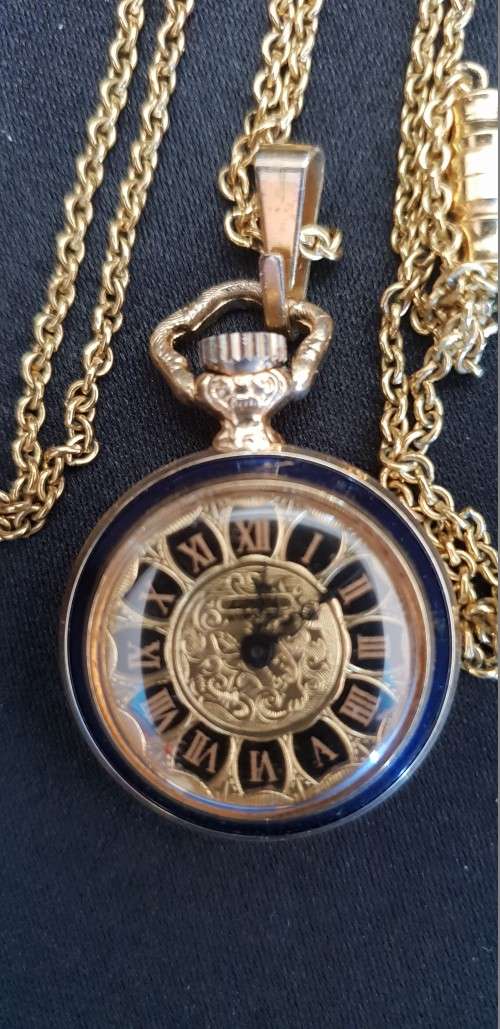 Miniature gold tone pocket watch on chain with blue enamel flower back