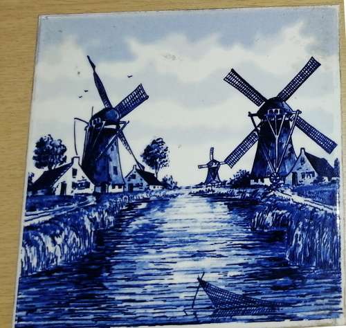 A Collection of three Delft tiles with windmill theme and one tile holder