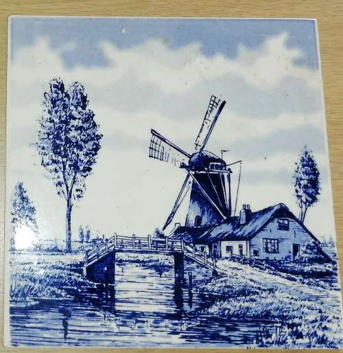 A Collection of three Delft tiles with windmill theme and one tile holder