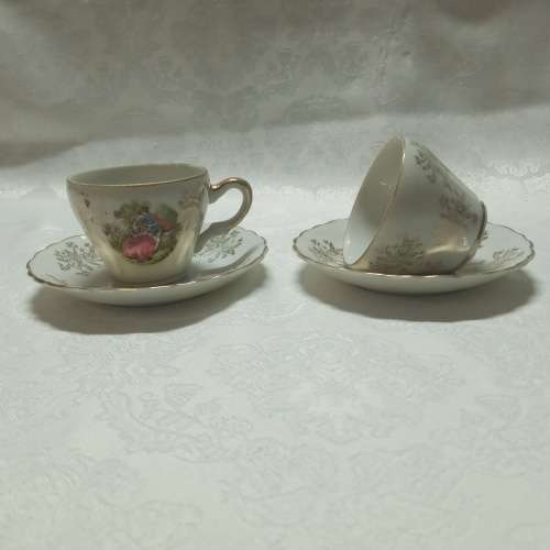 Two demitasse cups & saucers with romantic scenes