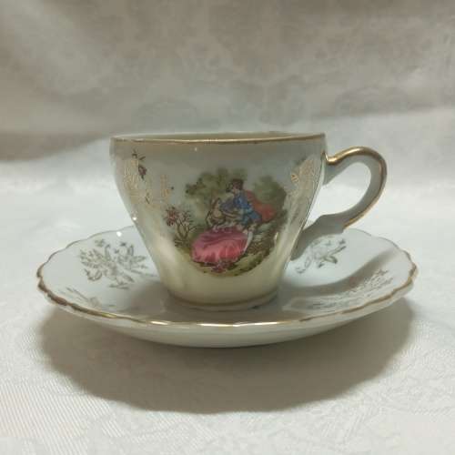Two demitasse cups & saucers with romantic scenes