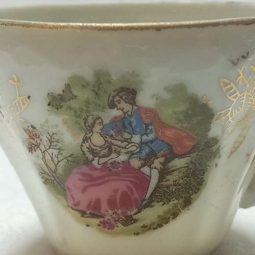 Two demitasse cups & saucers with romantic scenes
