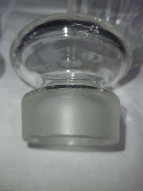 A SET OF 2 STORAGE GLASS BOTTLE CONTAINERS THE ONE LID WAS REPAIRED BEFORE SOLD AS IS
