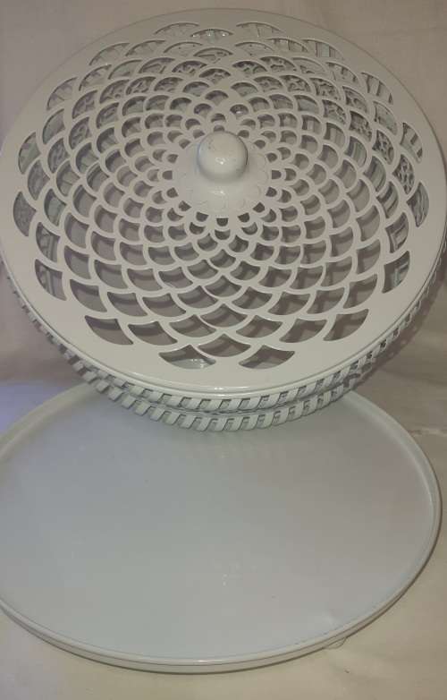 A WHITE ENAMEL PAINTED STEEL CAKE TRAY WITH AN ORNATE LID SOLD AS IS