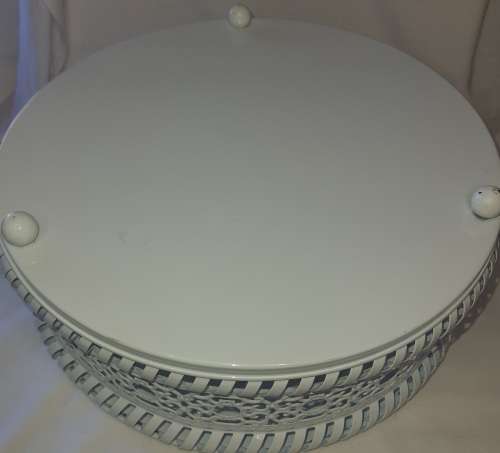 A WHITE ENAMEL PAINTED STEEL CAKE TRAY WITH AN ORNATE LID SOLD AS IS