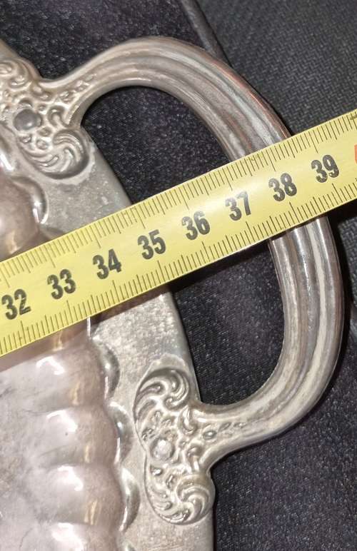 A VINTAGE ORNATELY ENGRAVED SILVER-PLATED SERVING TRAY SOLD AS IS