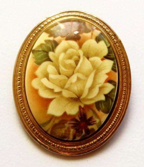 Vintage porcelain brooch pin in a gold tone setting with rose decoration