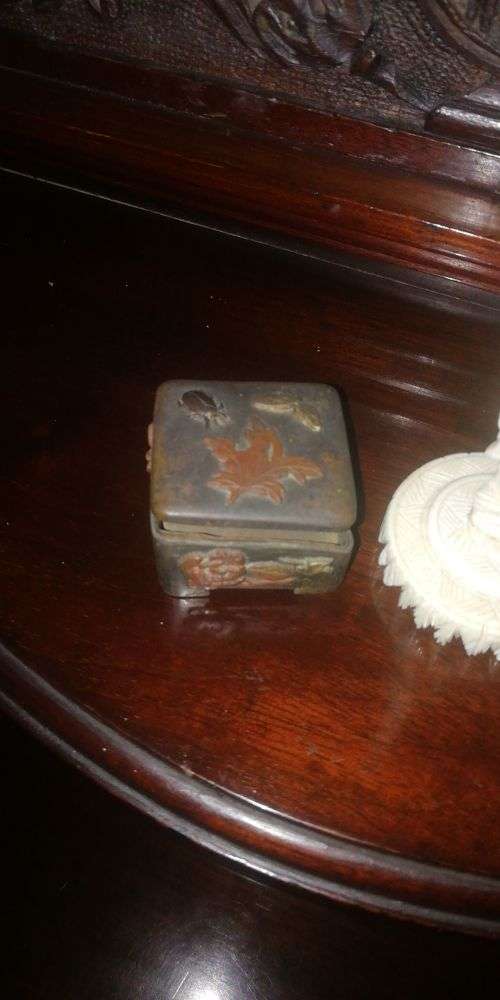 An ivory carved miniature figure and metal box