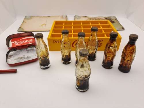 4 Vintage Coca Cola Items. Miniture Crate with 7 Coke bottles, 2 Metal Postcards and note Tin