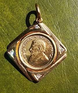 1/10TH OZ KRUGERRAND SET IN 9CT GOLD WITH 4 SMALL DIAMONDS 6.8 GRAMS 1984