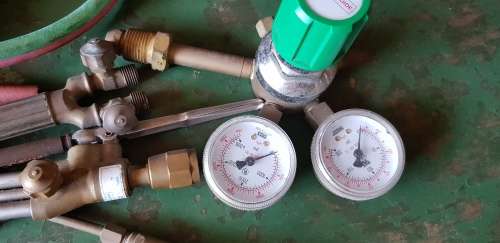 A box full of Jewellery tools Including metal roller and torches.