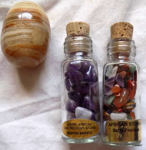 Two bottles with small semi precious stones, and 1 large polished stone.