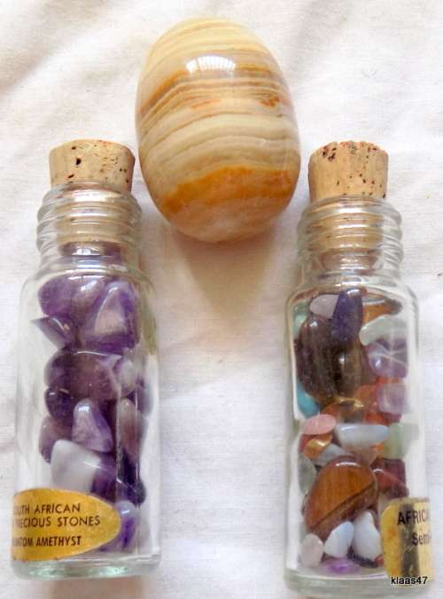 Two bottles with small semi precious stones, and 1 large polished stone.