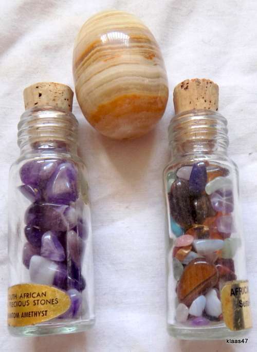 Two bottles with small semi precious stones, and 1 large polished stone.