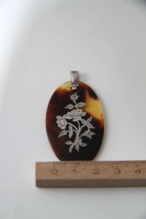 Tortoise shell pendant with sterling silver floral inlay