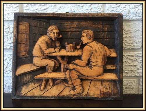 A wooden hand carved wall hanging. A pub scene