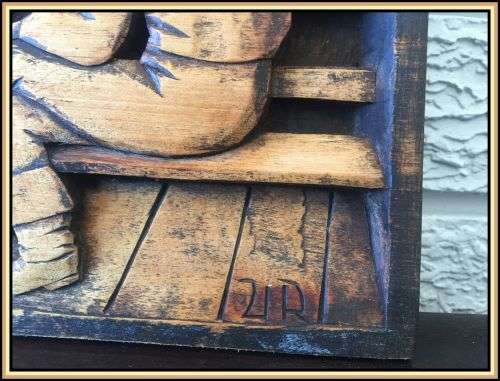 A wooden hand carved wall hanging. A pub scene