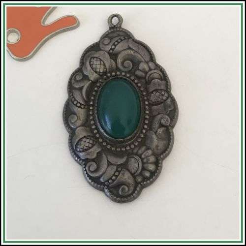 Antique silver repousse pendant with a green stone.