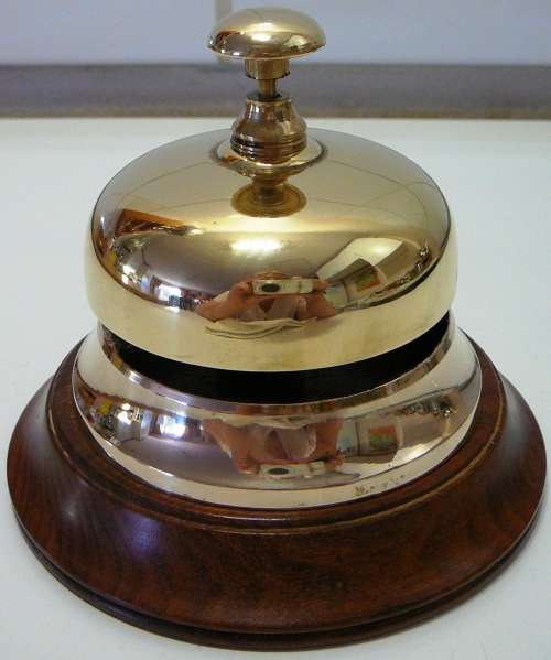 A Vintage Brass Counter Bell on Wooden Base