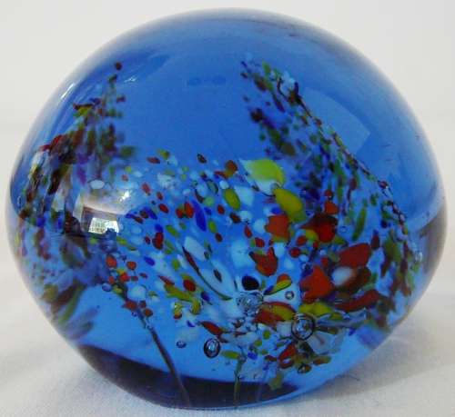 A Dark Blue Glass Paperweight with 3 Multi Coloured Flowers