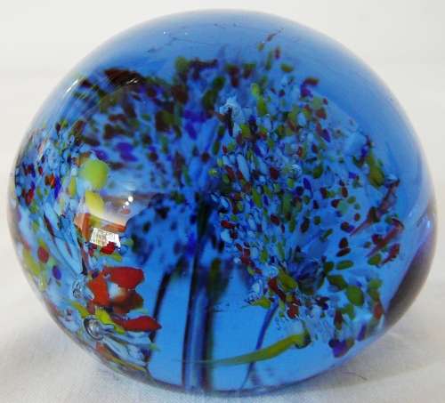 A Dark Blue Glass Paperweight with 3 Multi Coloured Flowers