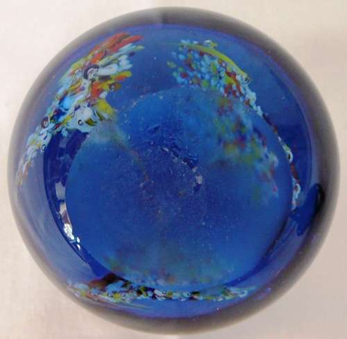 A Dark Blue Glass Paperweight with 3 Multi Coloured Flowers