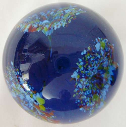 A Dark Blue Glass Paperweight with 3 Multi Coloured Flowers