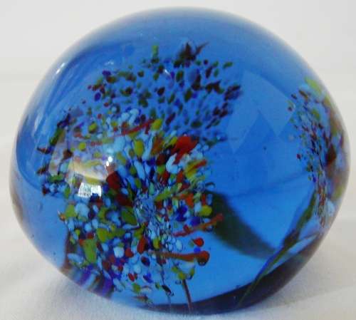 A Dark Blue Glass Paperweight with 3 Multi Coloured Flowers
