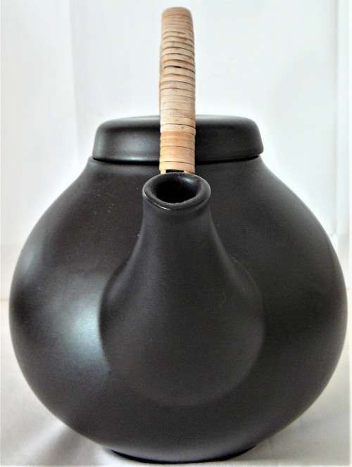 An Elegant Black Oriental Style Tea Pot with a Cane/Rattan Handle