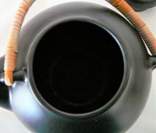 An Elegant Black Oriental Style Tea Pot with a Cane/Rattan Handle