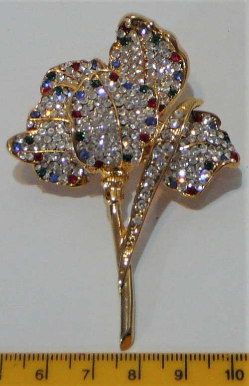 A Gold Coloured Flower Shaped Brooch Encrusted with Numerous Diamantes