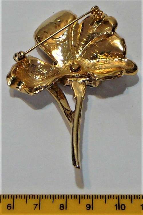A Gold Coloured Flower Shaped Brooch Encrusted with Numerous Diamantes
