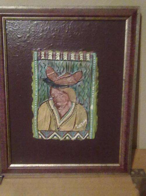 A Lessing clay art piece, framed