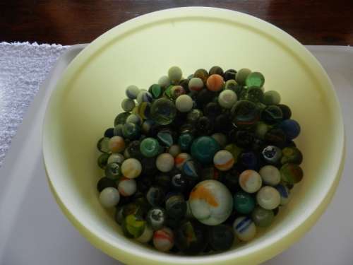 Vintage Marbles.  Plastic container full of glass marbles.