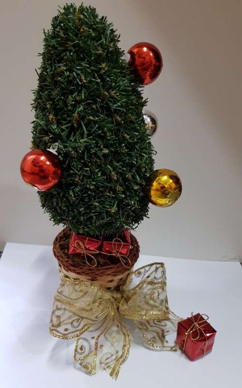 Vintage Christmas decoration. Small Christmas tree in basket with gifts under the tree