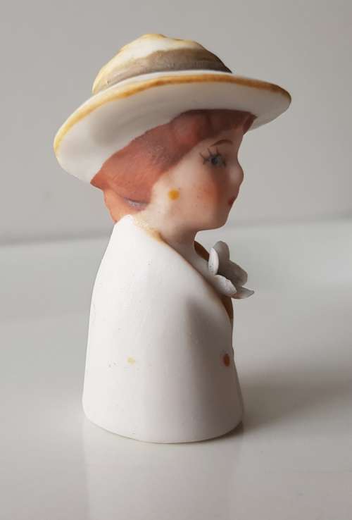 A Vintage collectors thimble. A Bisque Porcelain Thimble - Lady Wearing Hat.