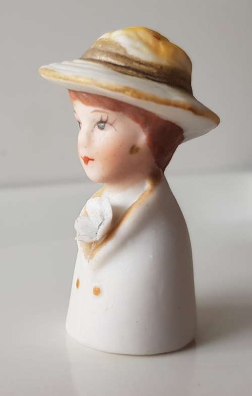 A Vintage collectors thimble. A Bisque Porcelain Thimble - Lady Wearing Hat.